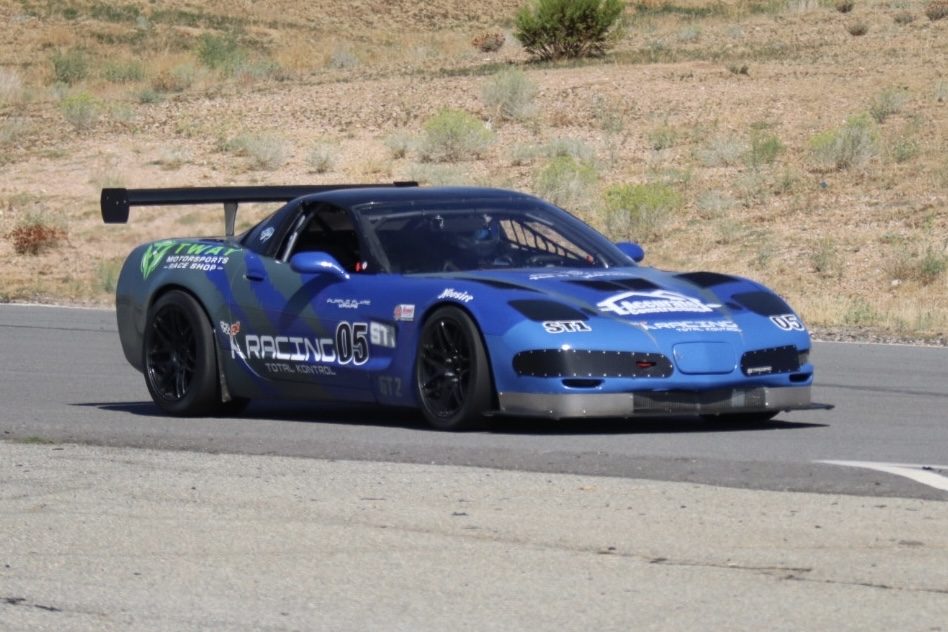 Blue #05 K Racing C5 Corvette at speed on a desert circuit
