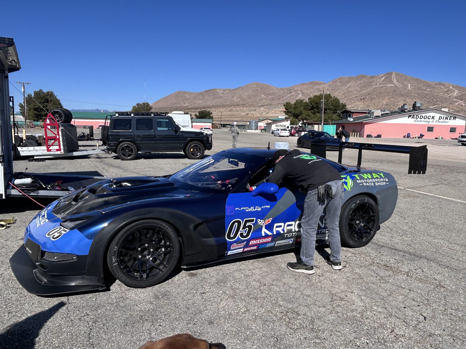 Crew working on the blue #05 C5 Corvette in the paddock