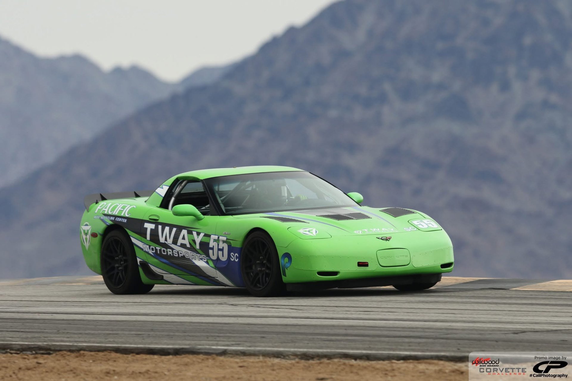 Green #55 C5 Corvette on track with mountains behind