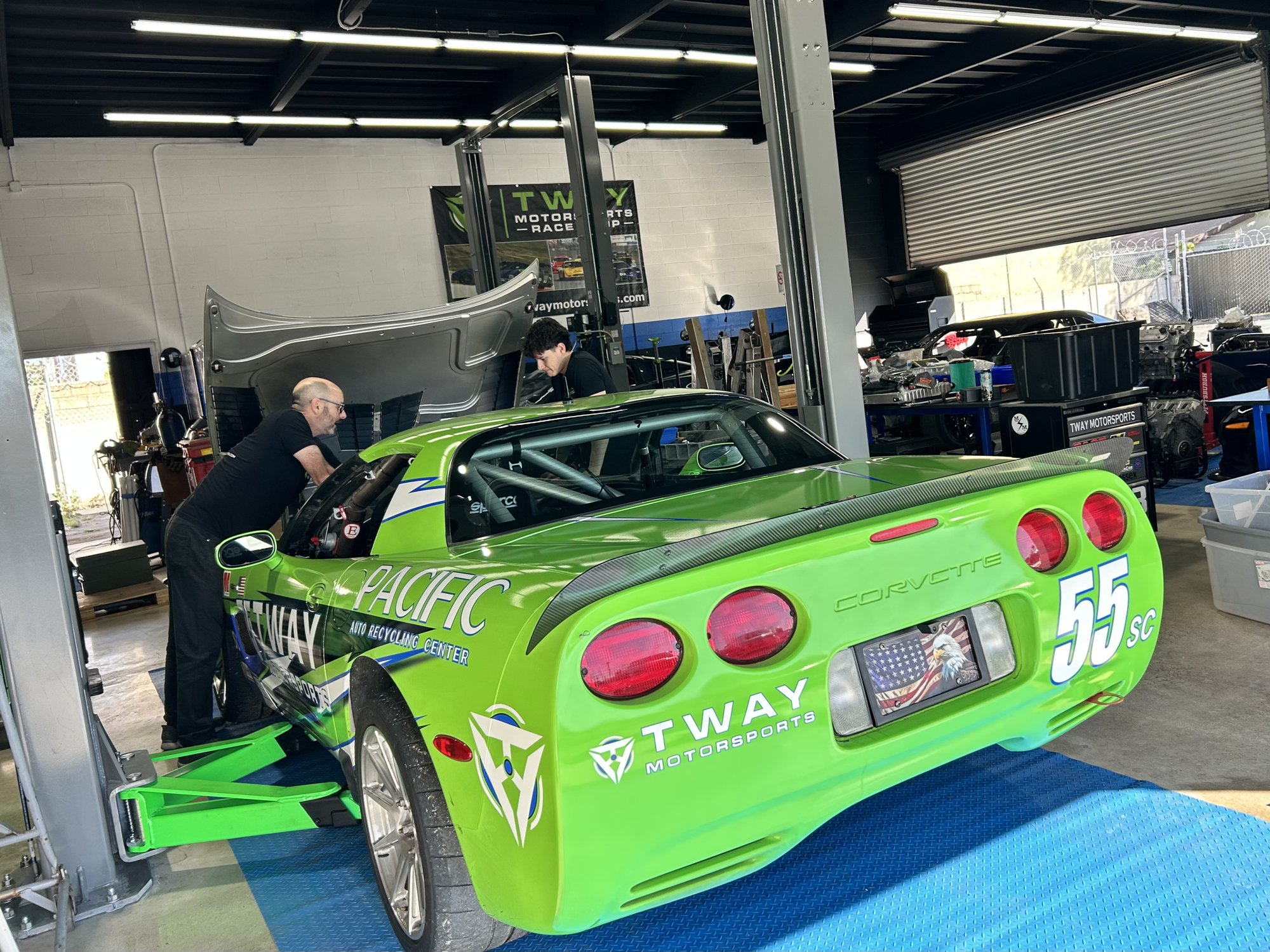 Green #55 C5 Corvette on the lift inside the Tway Motorsports shop