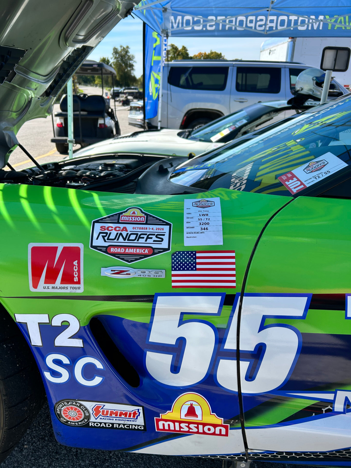 Green #55 C5 Corvette Z06 with the hood open in the Road America paddock