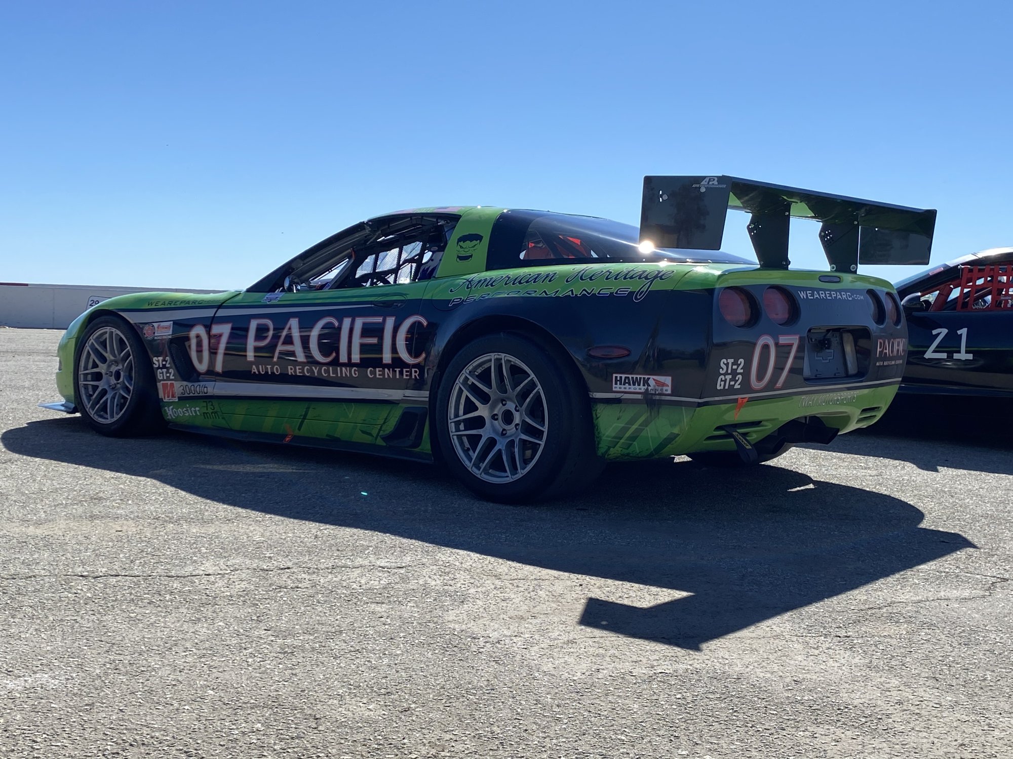 Green and black #07 C5 Corvette race car in the paddock