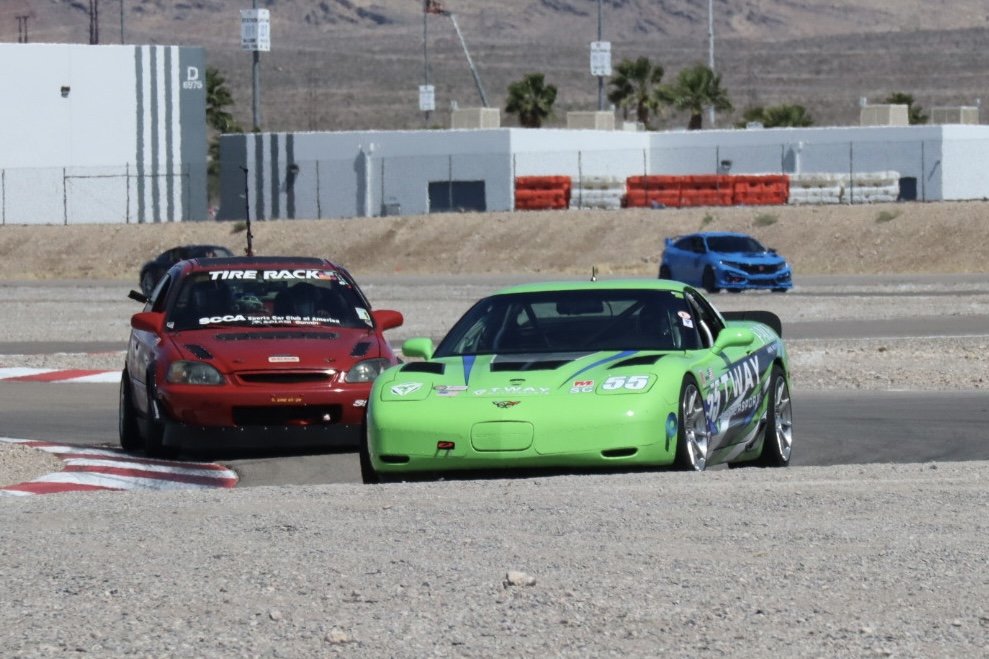 Green #55 C5 Corvette battling a red Civic on track