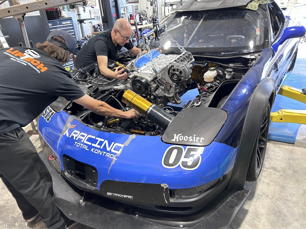 Engine install underway on a blue Corvette in the service bay